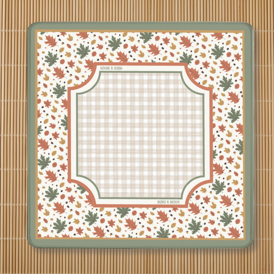 Autumn-themed American Mahjong mat with a falling leaves border, acorns, and a neutral plaid playing centre on a cream background.