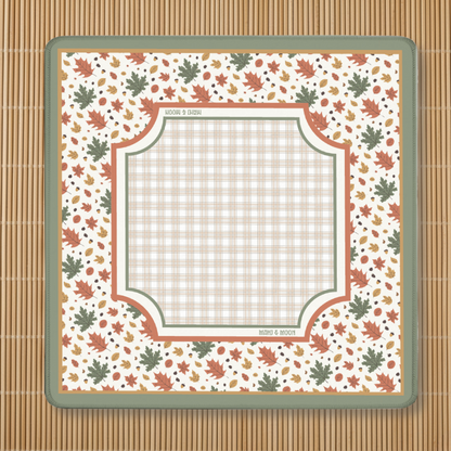 Autumn-themed American Mahjong mat with a falling leaves border, acorns, and a neutral plaid playing centre on a cream background.