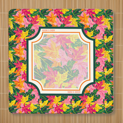 Autumn Leaves American Mahjong mat featuring colourful maple leaves in pink, orange, yellow and green with a coordinating foliage playing area, stitched edges, and non-slip rubber backing.