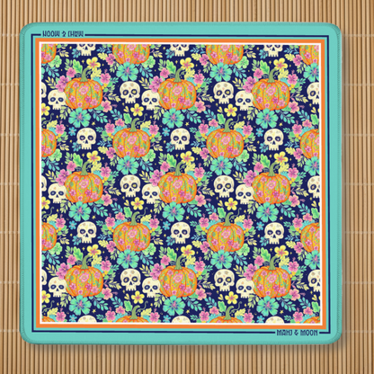 Halloween American Mahjong mat featuring colourful floral pumpkins, sugar skulls and botanical flowers on a navy background with a turquoise border and non-slip rubber backing.